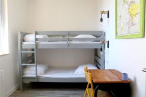 a bunk bed in a room with a table at Le Logis d'Anaïs in Trémont