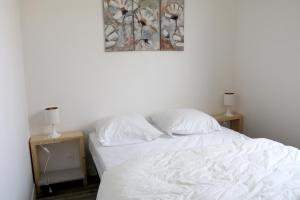 a bedroom with a white bed with two night stands at Le Logis d'Anaïs in Trémont