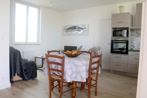 a kitchen with a table with a bowl of fruit on it at Le Logis d'Anaïs in Trémont
