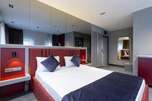 a bedroom with a large bed with a red headboard at Abone Suites in Istanbul