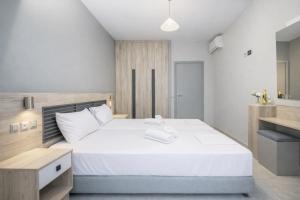 een slaapkamer met een groot wit bed in een kamer bij Maritina Apartments in Ixia +53 foto's