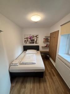 a small bedroom with a bed and a window at Christoph's mountain and lake view in Pflach