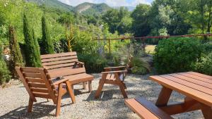 two benches and a picnic table in a garden at Auberge de Trente Pas in Saint-Ferréol-Trente-Pas