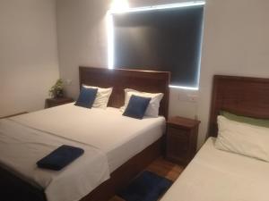 a bedroom with two beds with blue pillows at Solace Transit Villa in Katunayaka