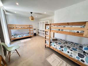 a room with two bunk beds and a chair at CORRALEJO SURF HOUSE & SCHOOL only SURF in Corralejo +41 photos