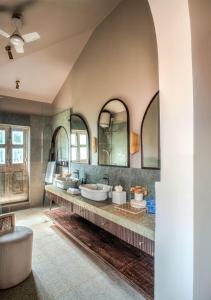 a bathroom with three sinks and two mirrors at LohonoStays Castello Villa 2 in Assagao +13 photos