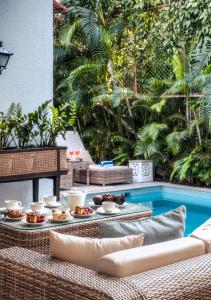 a table with food on it next to a pool at LohonoStays Castello Villa 2 in Assagao