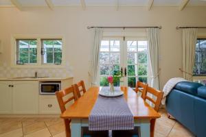 a dining room with a table and a blue couch at Big Brook Retreat in Pemberton
