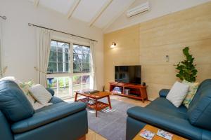 a living room with two blue couches and a table at Big Brook Retreat in Pemberton