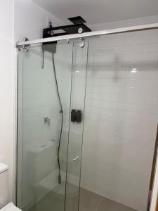 a shower stall with a glass door with a scale on top at Luxo e Aconchego 1Qt Com Sacada GY03 proximo Vaca Brava in Goiânia +16 photos