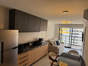a kitchen with a refrigerator and a couch in a room at Luxo e Aconchego 1Qt Com Sacada GY03 proximo Vaca Brava in Goiânia