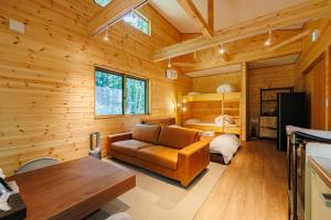 a log cabin living room with a couch and a bed at Narusawa MADOKA in Narusawa