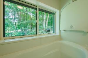 a white bath tub in a room with a window at Narusawa MADOKA in Narusawa +90 photos