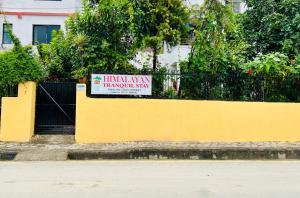 a yellow wall with a sign on it at Himalayan Tranquil Stay in Burhānilkantha