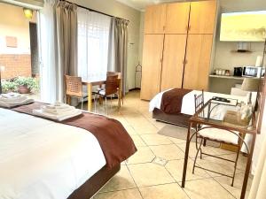 a hotel room with two beds and a table and chairs at Clubview Guest House in Centurion