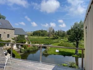 a deck with a view of a river from a house at Gîte Sieck Moulin de Kerellec in Plougoulm