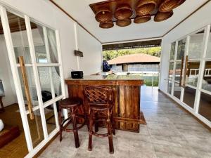 a kitchen with a bar with stools and windows at ลอยภิรมย์ Loypirom in Ban Huai Sai +38 photos