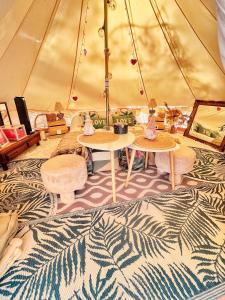 tenda con tavoli e sedie in camera di LOVE ROOM Tente chauffée Lodge spa MFG chez C&C, exclusivement réservée aux ADULTES a Cantaron