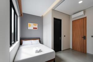a small bedroom with a bed and a window at Cove Alexa in Jakarta