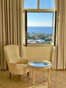 a chair and a table in a room with a window at Parco dei Principi Resort & Spa in Ischia