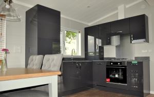 a kitchen with black cabinets and a table at Riverside Holiday Park in Amberley