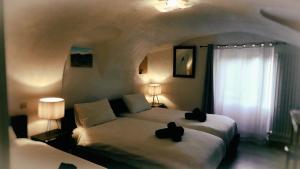 a bedroom with a bed with two black cats on it at Auberge Saint Martin in La Brigue