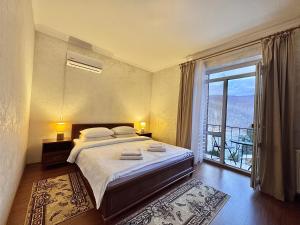 a bedroom with a large bed and a large window at Садиба в горах in Solochyn +205 photos