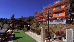 a person sitting on a bench in front of a building at The Unmad - Dharamkot in Dharamshala