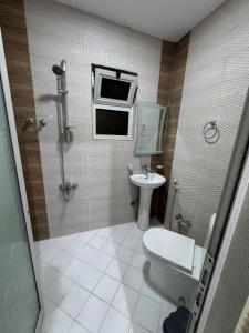 a bathroom with a toilet and a sink at المهيدب للشقق المخدومه 2 in Al Ahsa +28 photos