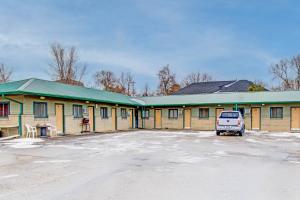 a car parked in a parking lot in front of a building at Bel Aire Motel Chamberlain Near Missouri River I 90 in Chamberlain