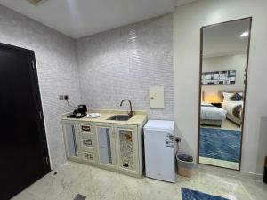 a kitchen with a sink and a refrigerator in a room at المهيدب للشقق المخدومه 2 in Al Ahsa
