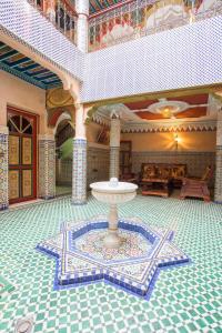 um quarto com uma fonte no meio de um edifício em Ryad Hamza em Marrakech