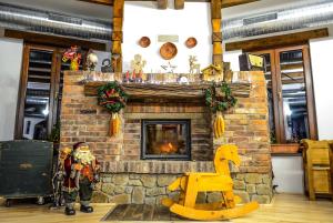 a living room with a brick fireplace with a christmas display at Hanul Teilor in Dăneşti