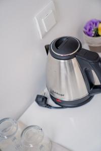 a tea kettle sitting on a counter with two glasses at Apartments BRAVO in Ohrid