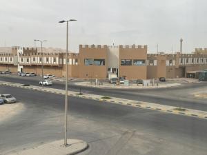 a street with cars parked in a parking lot at المهيدب للشقق المخدومه 2 in Al Ahsa