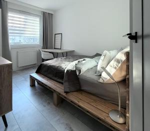 a bedroom with a bed and a table and a window at FARFA Harmonia Oliwska in Gdańsk +9 photos