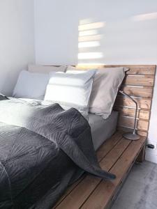 a bed with a wooden headboard and pillows at FARFA Harmonia Oliwska in Gdańsk