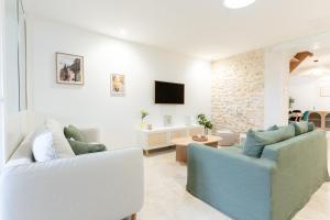 a living room with two couches and a tv at Serenity Appart', Les Clés de l'Espoir, proche Poitiers in Nieuil-lʼEspoir