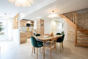 a kitchen and dining room with a wooden table and chairs at Serenity Appart', Les Clés de l'Espoir, proche Poitiers in Nieuil-lʼEspoir