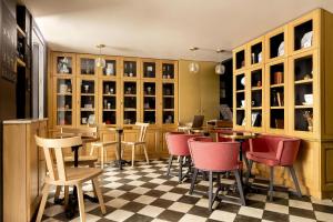 a restaurant with chairs and tables in a room at La Dépendance in Paris