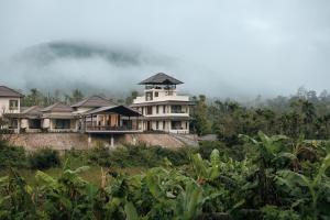 a house on top of a hill with trees at Kohu By Honeyvale in Mudigere
