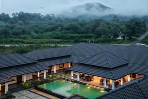 an aerial view of a house with a swimming pool at Kohu By Honeyvale in Mudigere