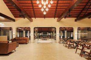 a lobby with tables and chairs and a chandelier at Kohu By Honeyvale in Mudigere