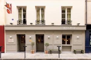 a building with two benches in front of it at La Dépendance in Paris