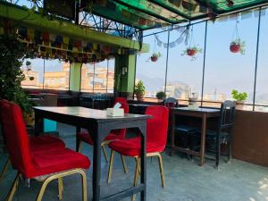 a restaurant with two tables and red chairs at Three Peaks Inn in Kathmandu