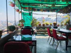 a restaurant with tables and chairs and a view at Three Peaks Inn in Kathmandu
