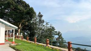 a fence on the side of a house with a view of the ocean at Ellem House in Kotagiri +8 photos