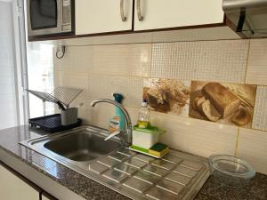 a kitchen counter with a sink and a microwave at Villa Capri first floor in Quatre Bornes