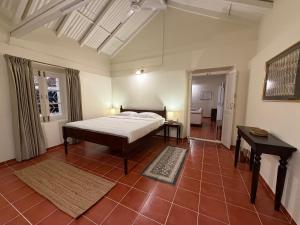 a bedroom with a bed and a table in it at Ellem House in Kotagiri