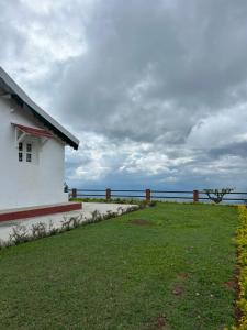 a white building with a view of the ocean at Ellem House in Kotagiri